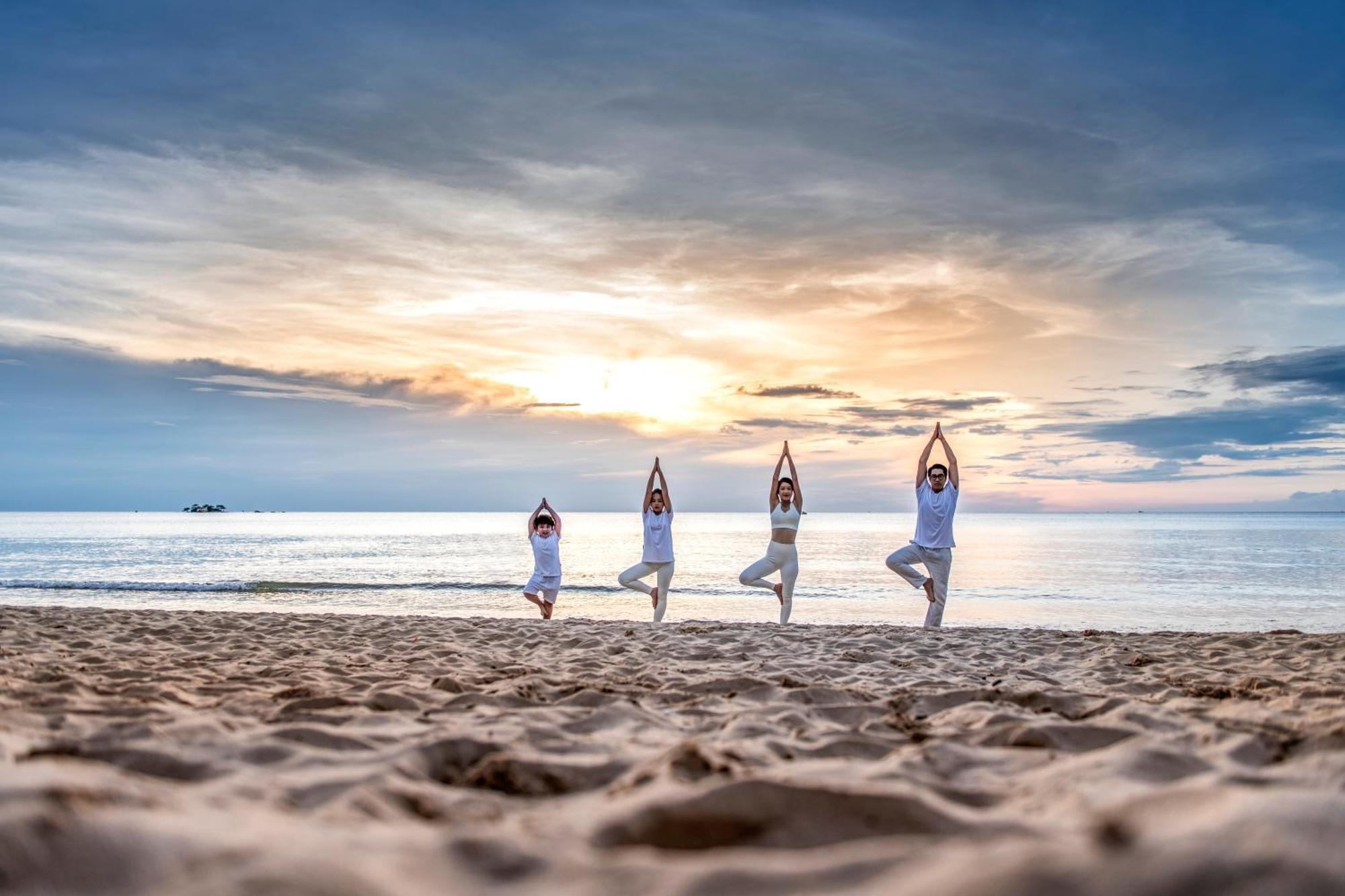 Vinpearl Wonderworld Phu Quoc Hotell Exteriör bild Family practicing yoga on the beach